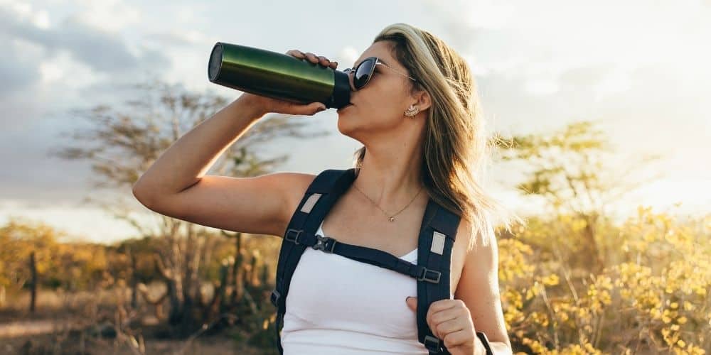 woman drinking from water bottle