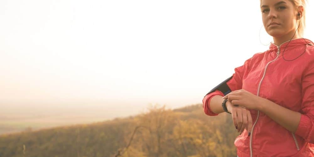 a runner with earbuds, apple watch, and other running devices